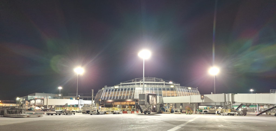 Dublin Airport featuring modern terminal architecture and high-mast LED lighting illuminating the apron area